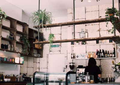 Charming rustic café interior with lush plants and a barista at work, featuring a vintage vibe.
