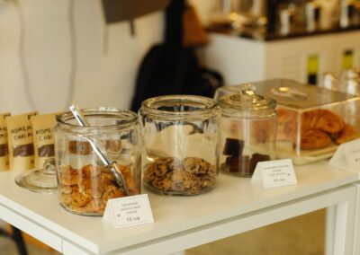 A warm café scene with cookies, pastries, and more in glass jars ready to tempt customers.