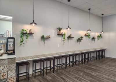 Stylish café interior with industrial lighting and nature-inspired decor featuring hanging lights and indoor plants.