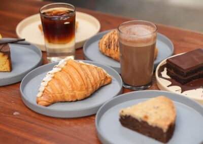 A variety of delicious pastries and drinks on plates, perfect for a cozy café experience.