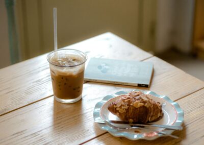 A serene coffee table setting with iced latte and almond croissant, perfect for a quiet break.